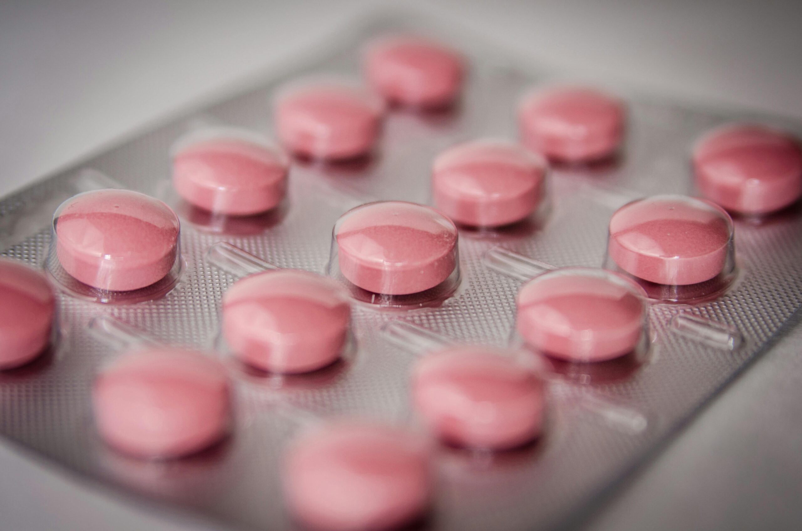 Pink tablets in a blister pack, emphasizing healthcare and medication concepts.