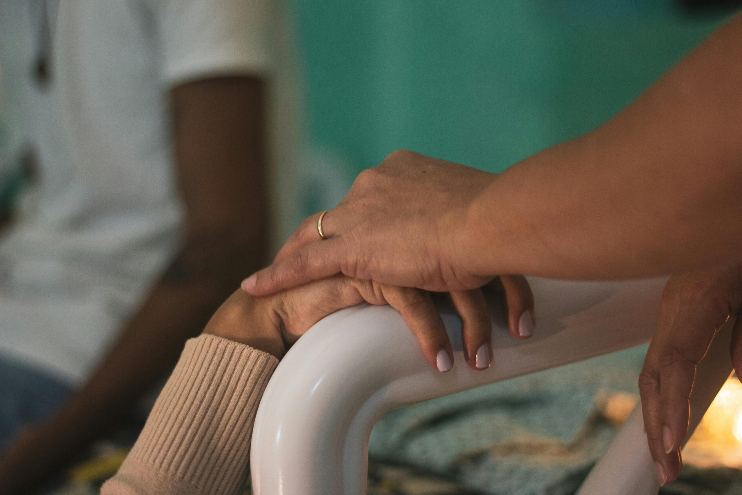 Close-up of comforting hands touching in a hospital room, symbolizing support and compassion.