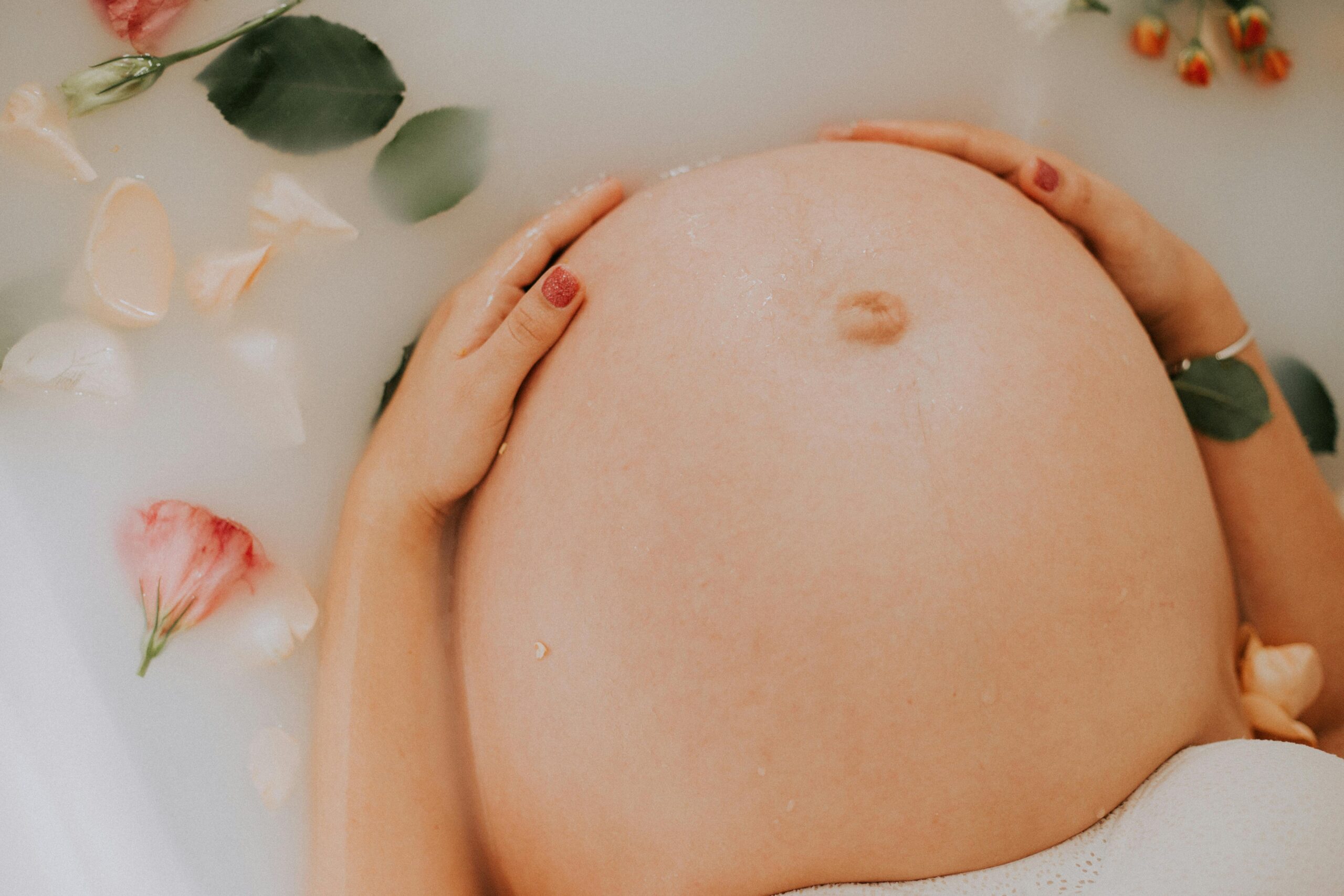 Pregnant woman relaxing in a soothing milk bath with flowers, embracing maternity.