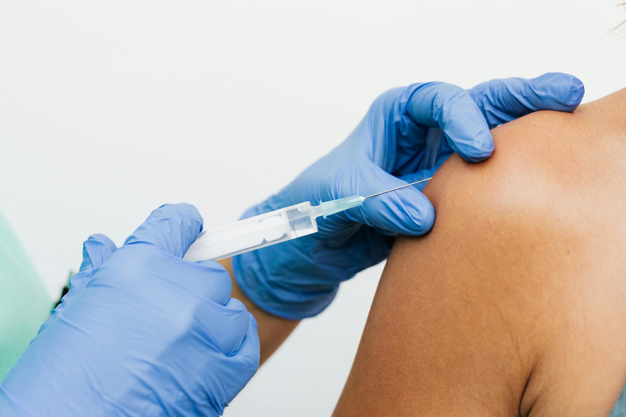 Close-up of a healthcare worker giving a vaccination injection to a patient