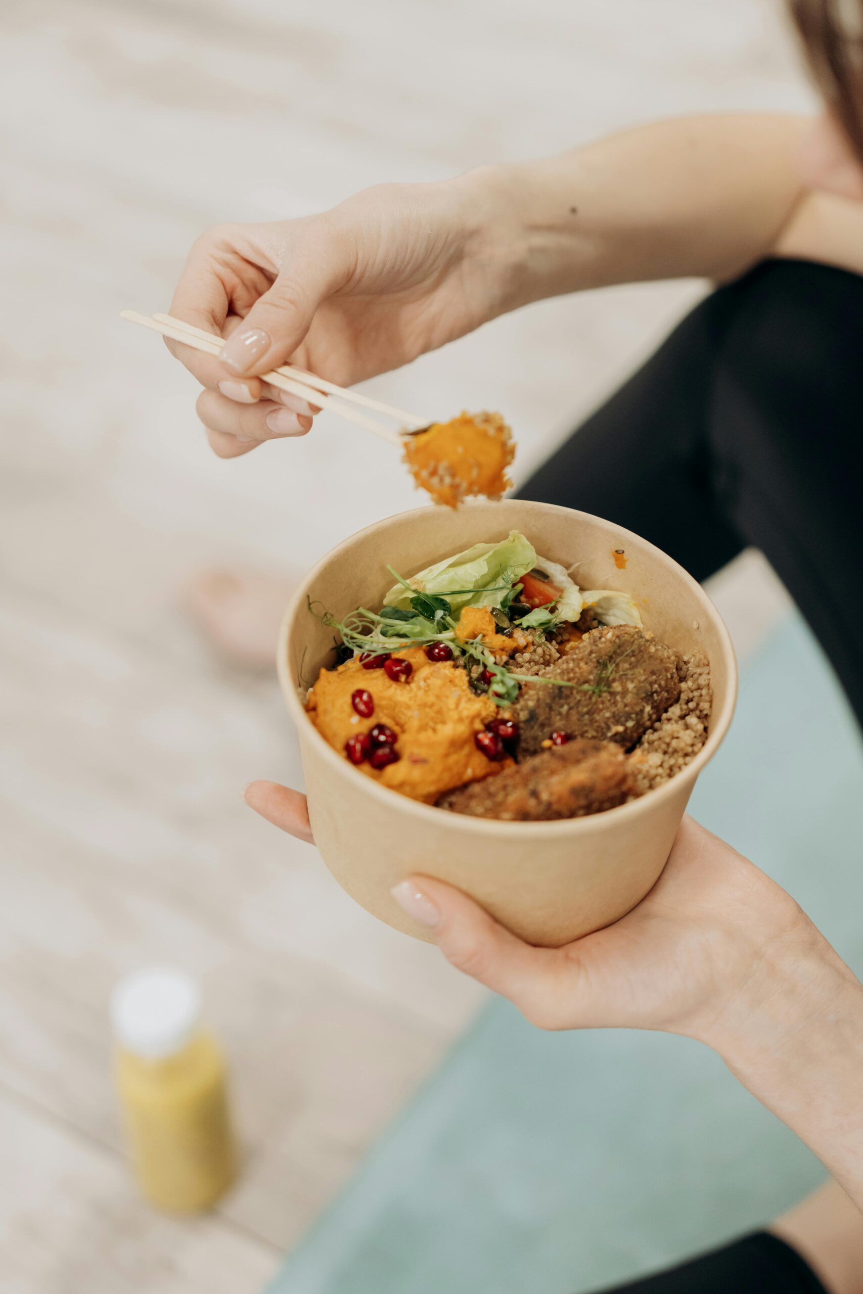 A close-up of a person enjoying a healthy meal with fresh vegetables and grains.