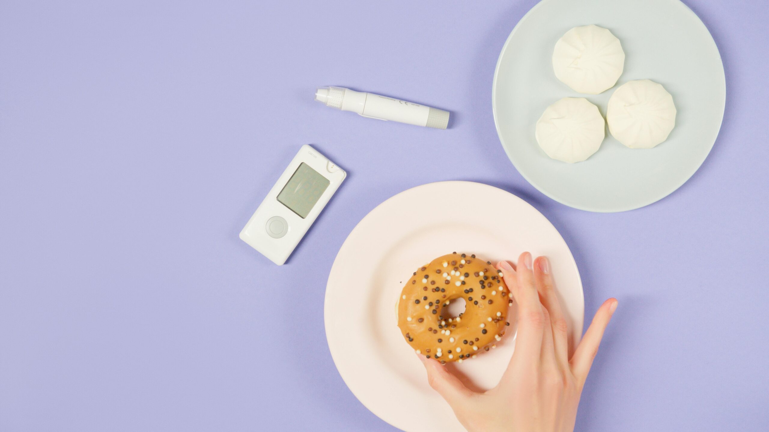 Flat lay of diabetes-related items with food on a pastel background.