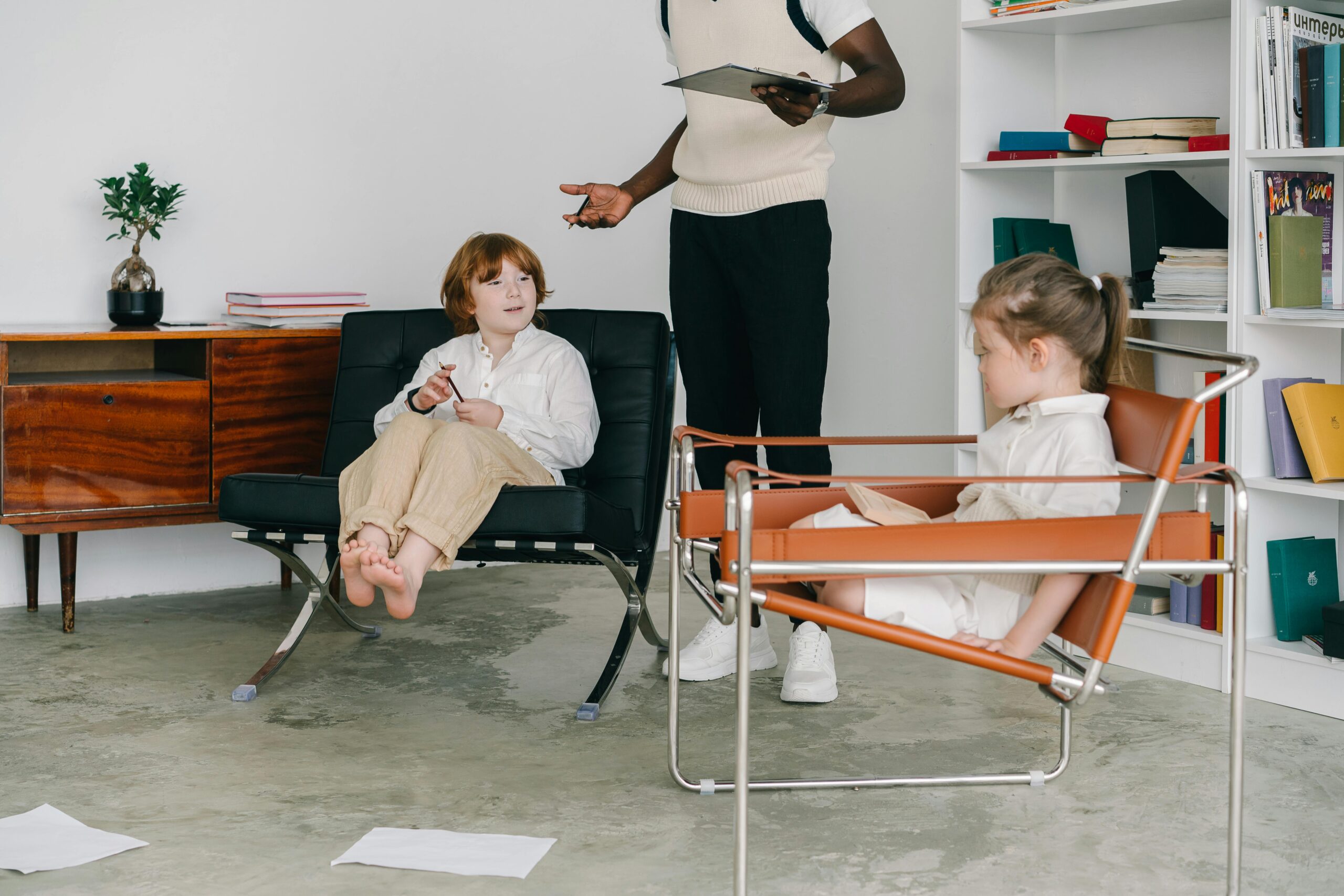 Children engaging in a therapy session with therapist in a modern office.