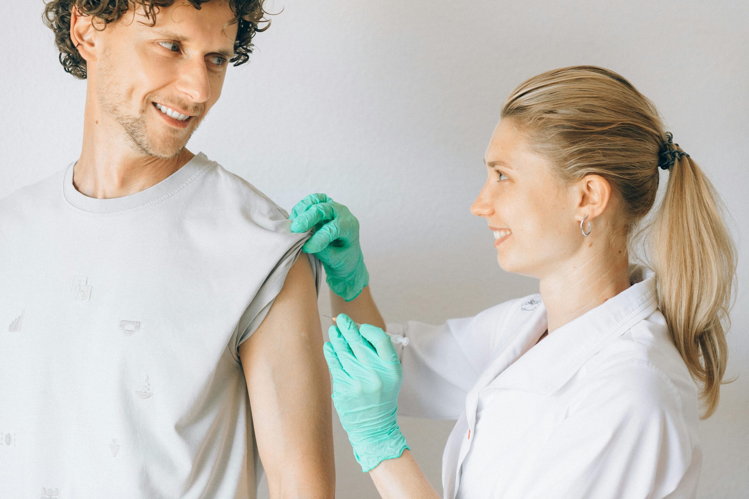 Nurse assisting an elderly patient in healthcare setting.