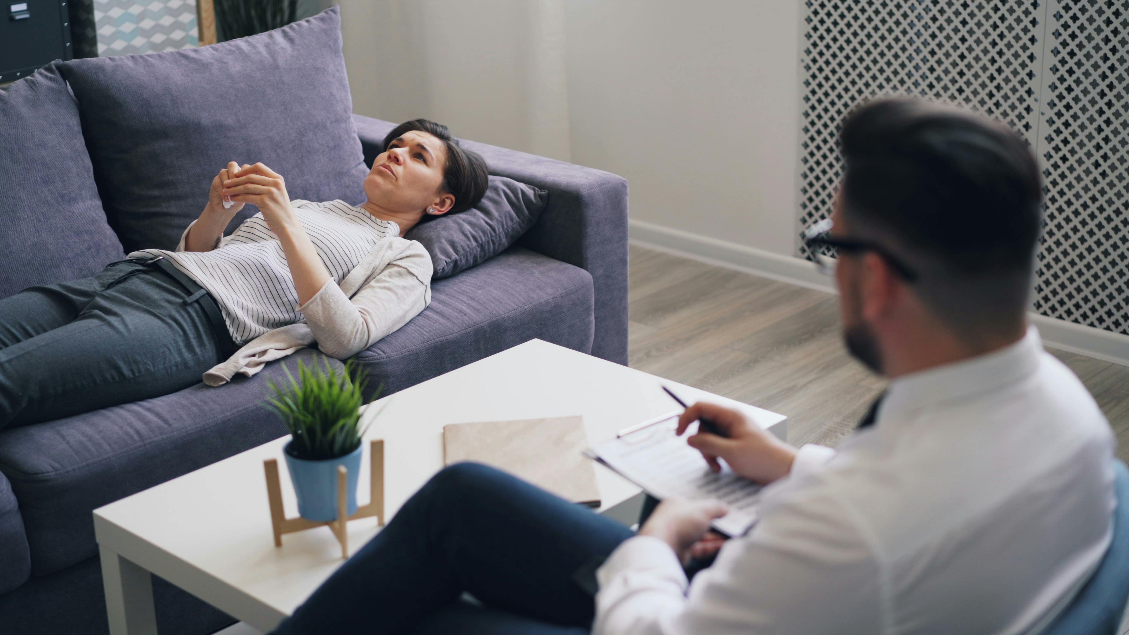 A woman engaged in a therapy session with a psychologist in a modern office setting.