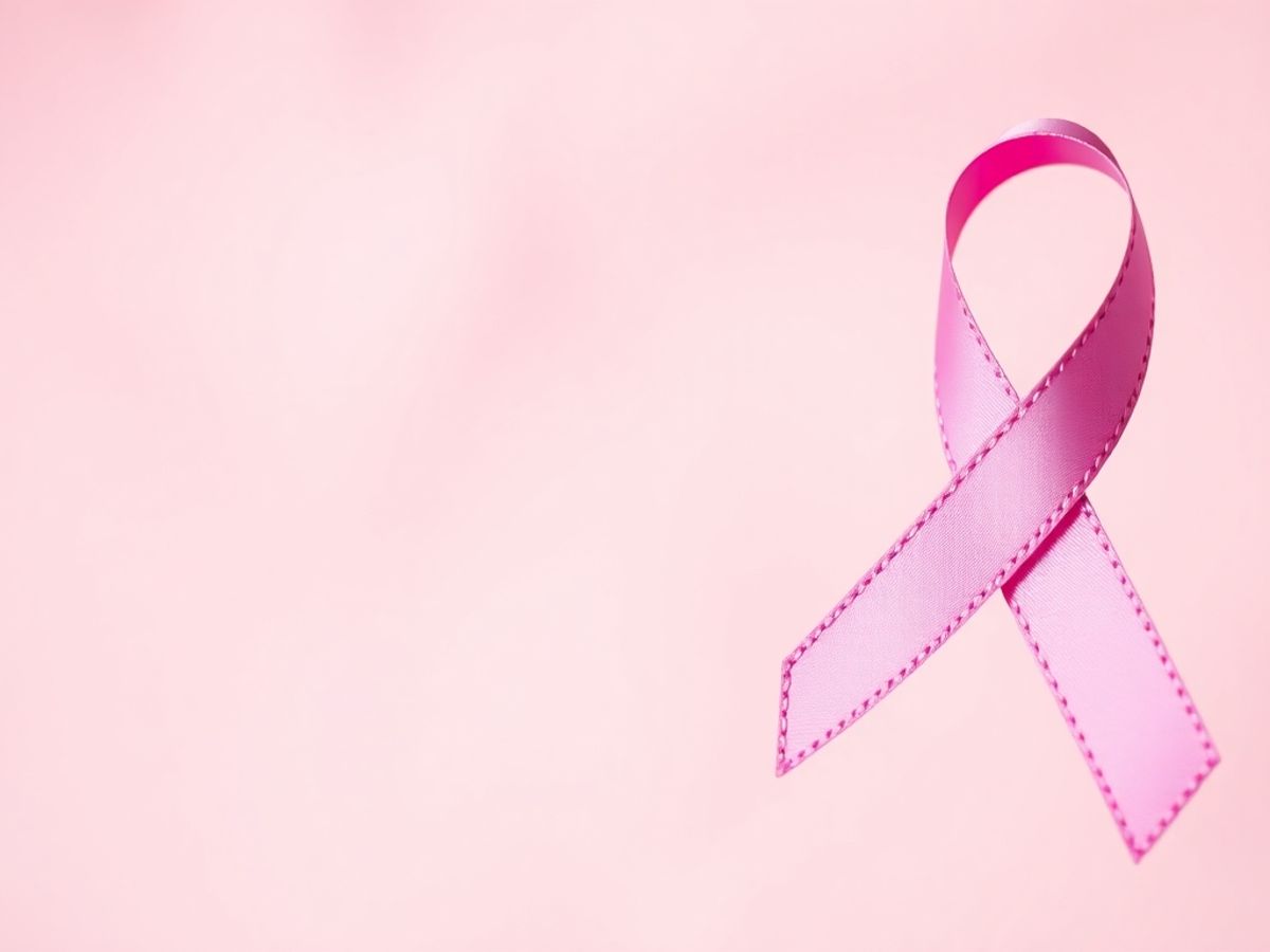 Pink ribbon for breast cancer awareness in soft background.